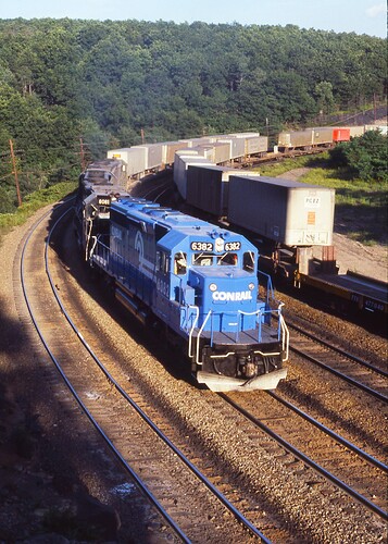 CR. Ex PC SD40-2 #6382, #8081 and  2 other units are west TV train at Bennington Curve. Afternoon on Aug 15, 1977
