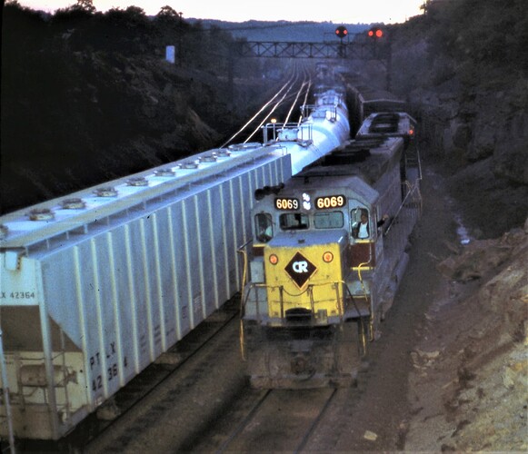 Conrail. Ex E-L SD 45 #6069 and other unit pushing a freight west  at Benny interlocking. evening in July 17, 1977