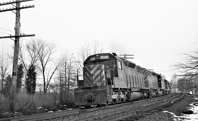 CNJ. SD-35 # 2506, #2511 and 2 other units with eastbound freight rounds the curve at the Rt 202 bridge at MP 38. Feb 1973