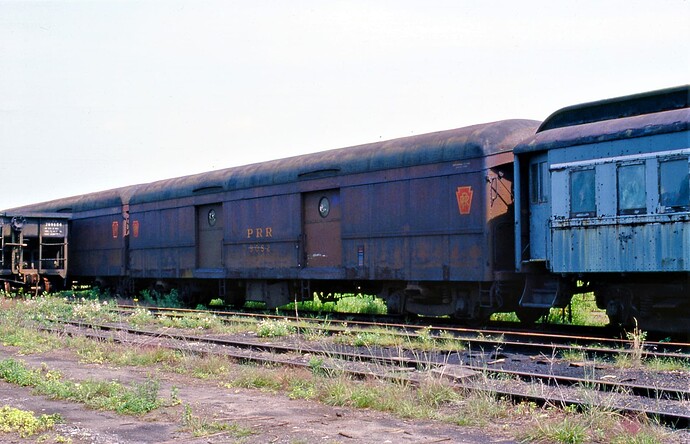 Conrail. Altoona, PA scrap line with ex PRR baggage car #9052. August 16, 1977