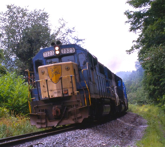 D&H. GP38-2 #7323, B&M GP 38-2, U25B and 4th unit with coal train enroute to Belden.  8-84