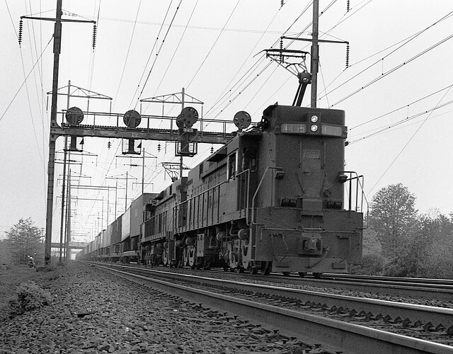 Penn Central. E-44 #4455 & other  E-44 with east TV train, trk 3. Signal 347, New Brunswick, NJ. August 1975