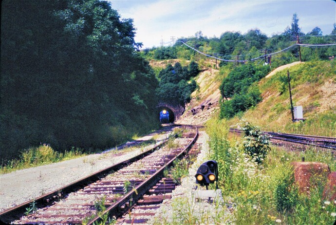 Conrail. Train leaving  Gallitzin tunnels heading east. Track to left is branch to Hollidaysburg, PA. August 1977
