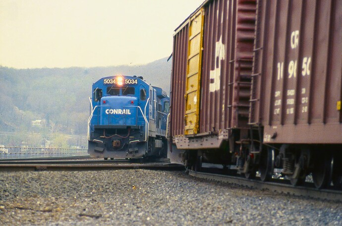 CR. B36-7 #5034 passes freight heading north on the P&E in the haze in August 18, 1986.