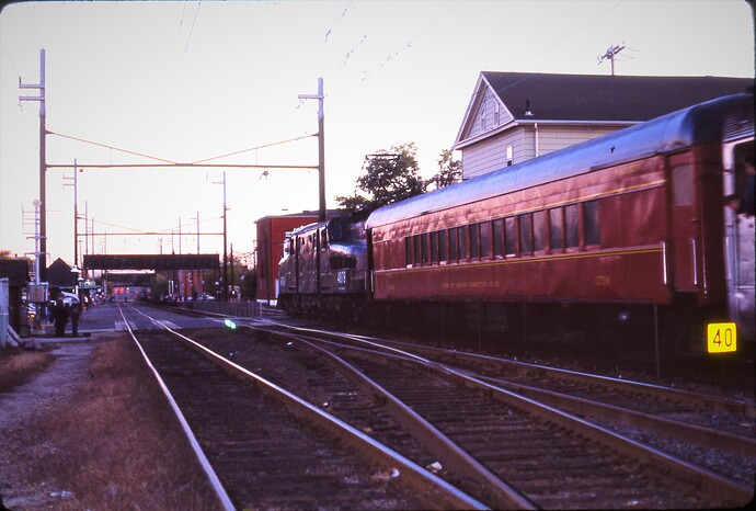 NJT. GG-1 #4879 with west NYC passenger, Jersey Shore Commuters Club car behind GG-1 at South Amboy, NJ. At Augusta St, Oct 1983