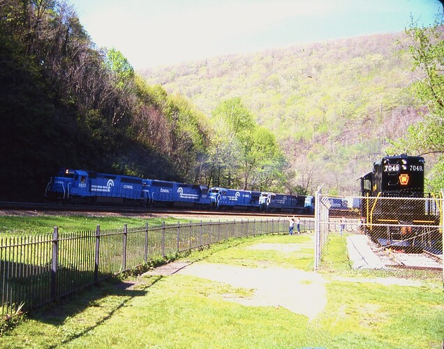 CR. SD45-2 #6665 (ex-EL #3680), #6654 (EL #3669), B36-7 #5029, #5044 & 5th unit, west at Horseshoe Curve passing GP-9 #7048 in May 1986
