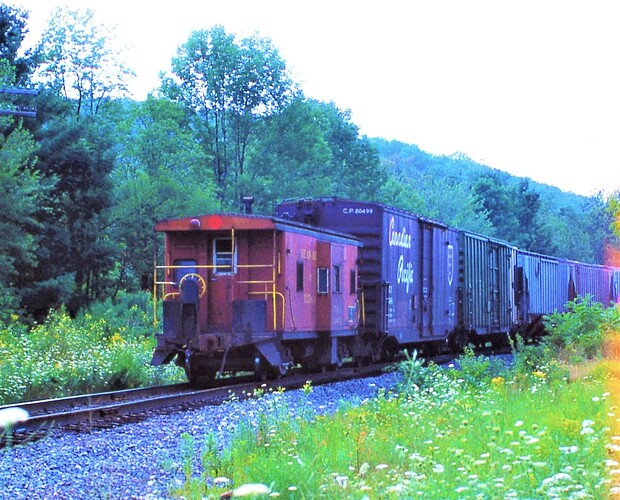 D&H. Caboose on freight with GP38-2 #7411 leading of Rt 7 near Saniteria Springs, NY.  Aug 1984