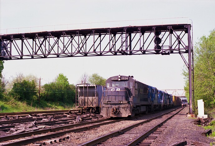 Conrail. GE U25B #2534 on freight.  West end of WX Weston Manville tower plant. June 18, 1982