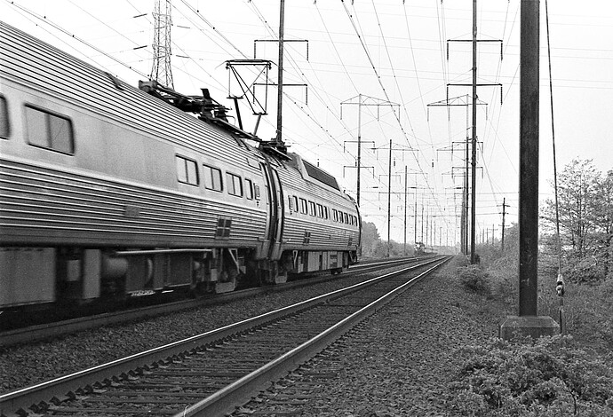 Amtrak. eastbound Metroliner meets westbound GG-1 passenger at signal #347. New Brunswick, NJ. August 1975