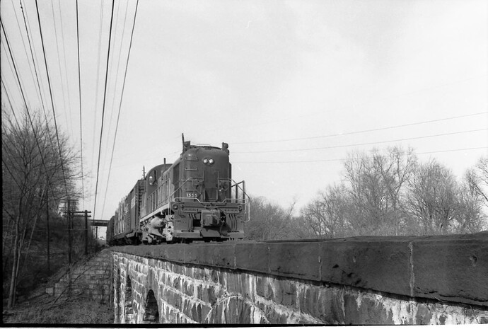 CNJ. RS-3 #1555 with eastbound freight at North Branch, NJ bridge over North Branch of Raritan River. March 1972