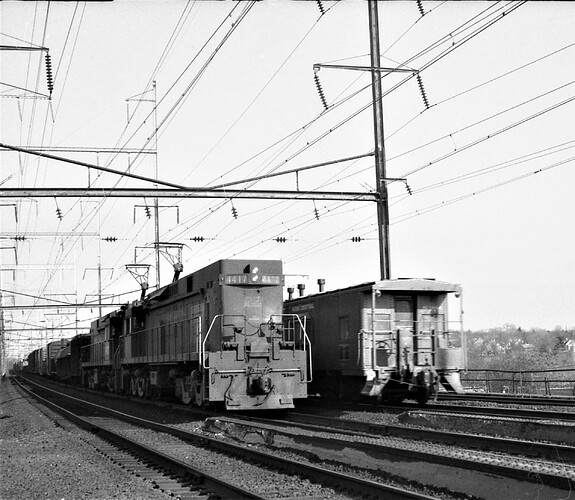 Penn Central E-44 #4417 with freight passing eastbound freight in New Brunsiwck, NJ. September 1975