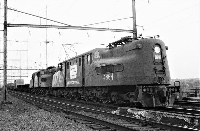 Penn Central. GG-1 #4864 & other on westbound freight in New Brunswick, NJ. June 25, 1975