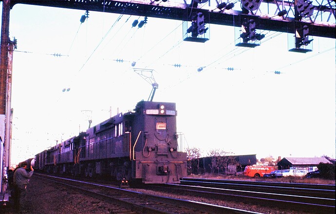 PC.  E-44 #4443 with red P & 2 others  on westbound freight trk 3 at County Tower interlocking, New Brunswick, NJ. Nov 1971