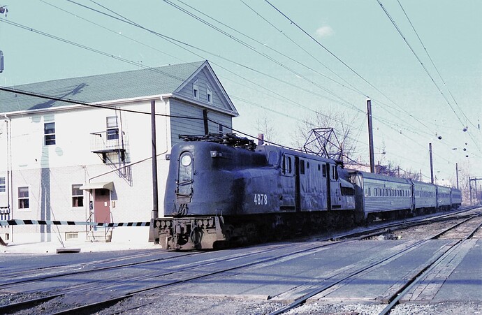 NJT. GG-1 #4878 with NYC train crossing Augusta St at So. Amboy, NJ  for engine transfer to E-8's for Bay Head, NJ run. 1983