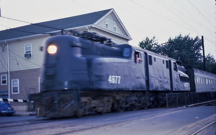 NJT. GG-1 #4877 arriving at South Amboy, NJ with train from NYC. in the evening in September 1982