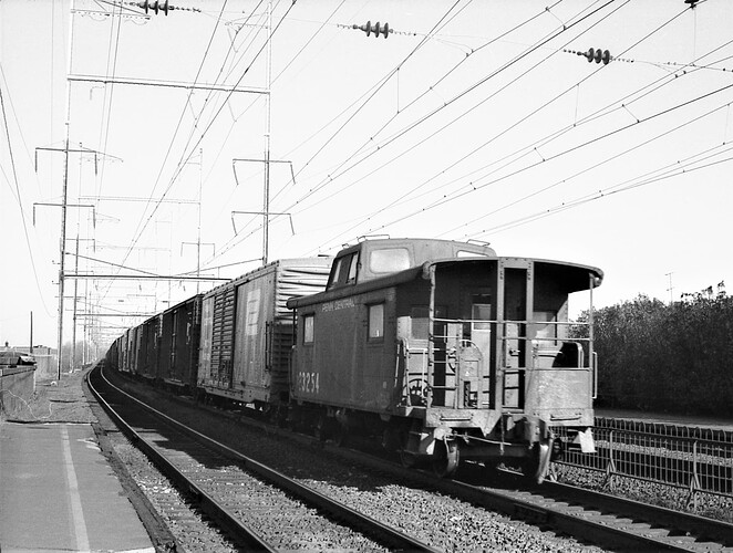 Penn Central ex PRR caboose #23254. Eastbound in New Brunswick,NJ. 1974