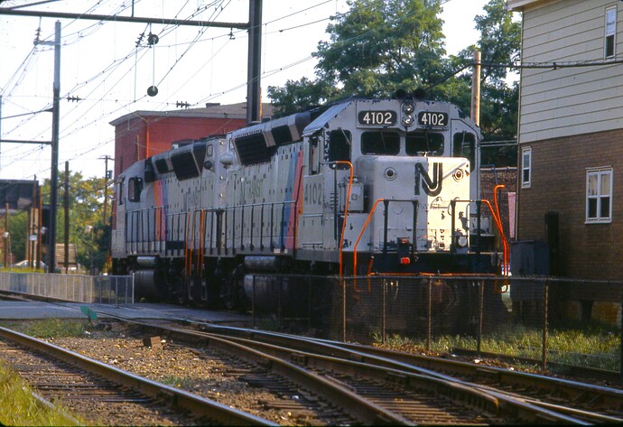 NJT. GP40-P #4105 (#3679) & #4102 (#3675) crossing Augusta St. South Amboy, NJ. Oct 1983