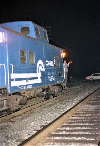 Conrail rear brakeman signaling to engineer at New Market Ave crossing, Piscataway, NJ. Oct 5, 1981